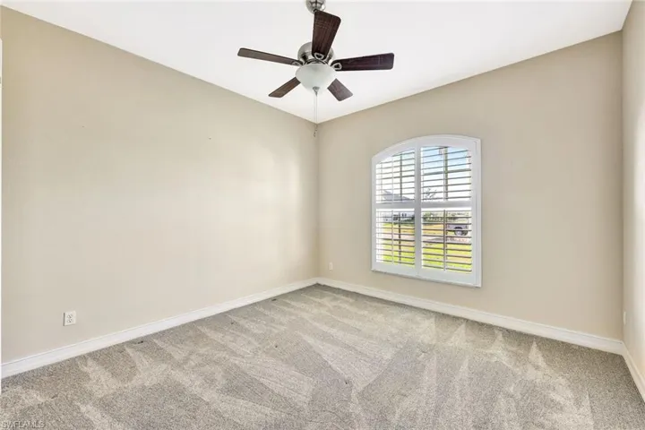 Unfurnished room featuring baseboards, carpet, and a ceiling fan