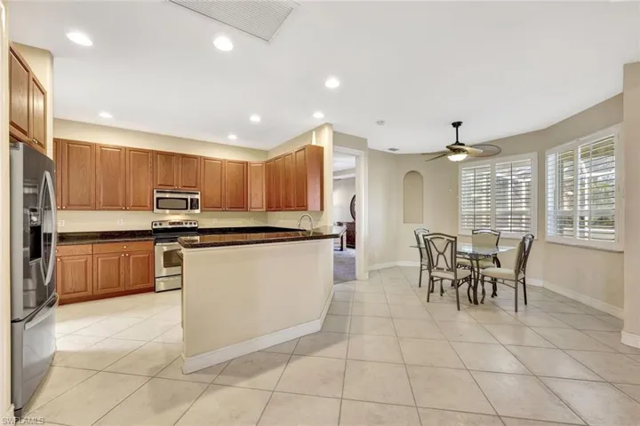 Kitchen featuring recessed lighting, light tile patterned floors, arched walkways, visible vents, and appliances with stainless steel finishes