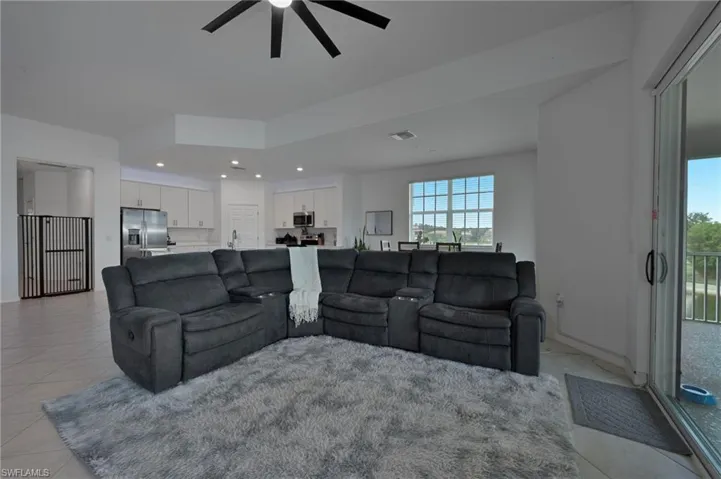 Living room featuring light tile patterned floors, recessed lighting, and a ceiling fan