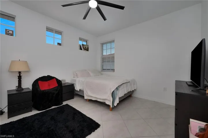 Bedroom with ceiling fan and light tile patterned floors