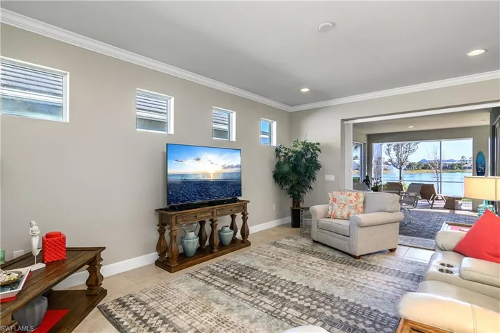 Living room with light tile patterned floors and crown molding