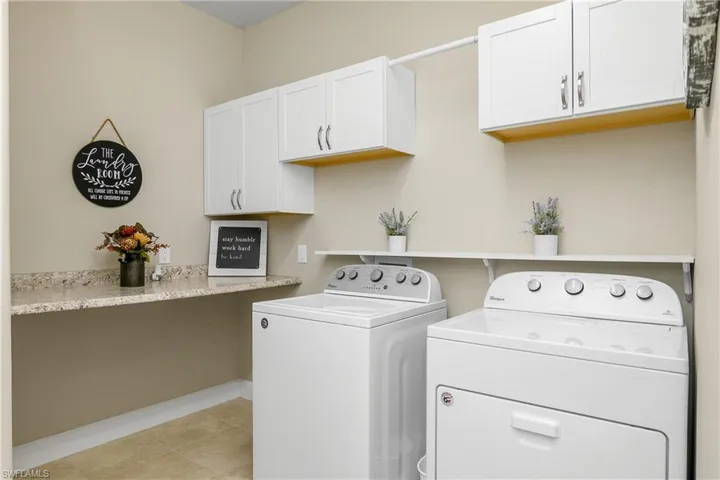 Washroom with cabinets, separate washer and dryer, and light tile patterned floors