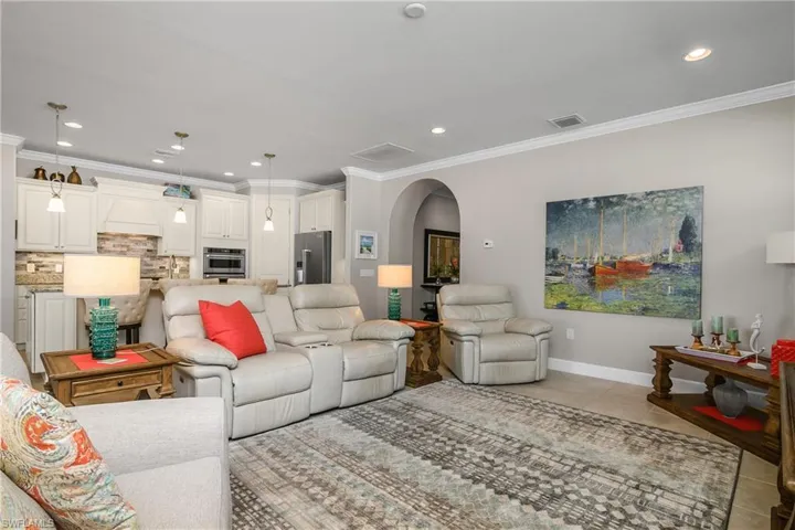 Living room featuring crown molding and light tile patterned floors