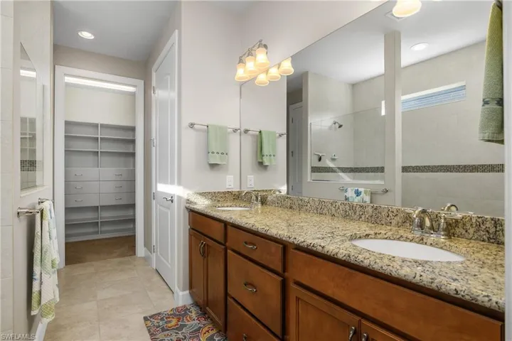 Bathroom featuring tile patterned floors, vanity, and a shower