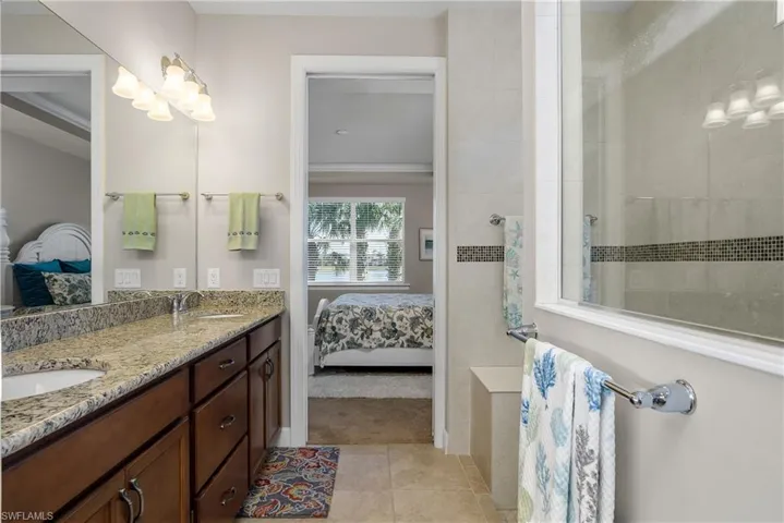 Bathroom with vanity, tile patterned flooring, and a shower