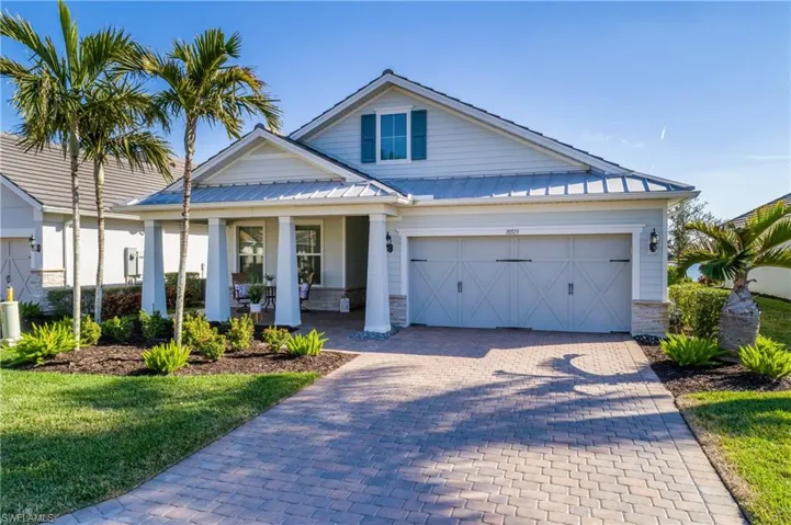 View of front of home featuring a garage, a front yard, and covered porch