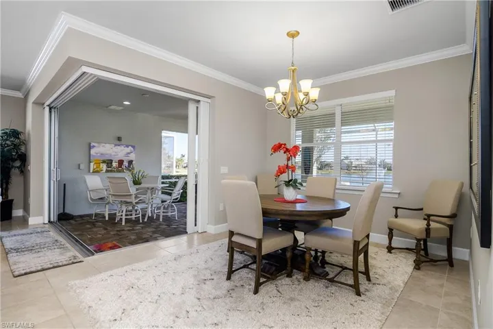 Tiled dining area featuring ornamental molding and a chandelier