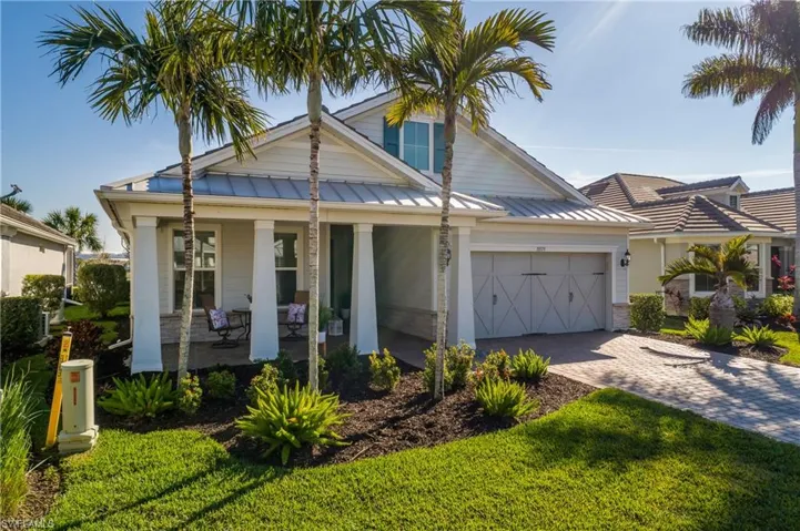 View of front of property with a garage, a front lawn, and covered porch