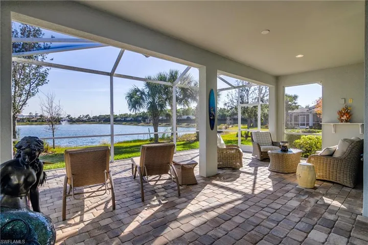 View of patio / terrace featuring a water view and glass enclosure