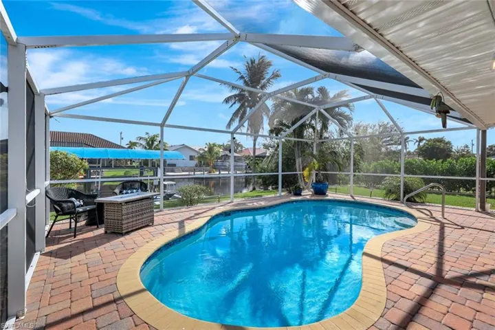View of pool featuring a patio, a water view, and a lanai