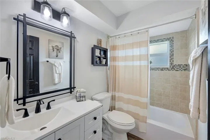 Full bathroom featuring toilet, shower / bath combo, and vanity
