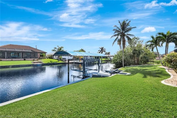 Dock area with a yard and a water view