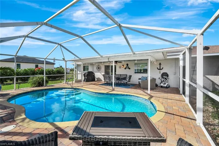View of swimming pool with ceiling fan, a lanai, and a patio
