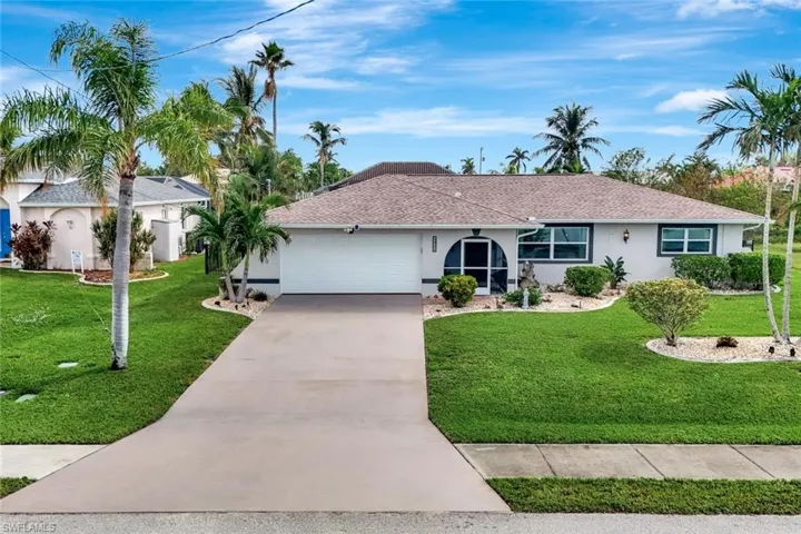 Ranch-style house featuring a garage and a front lawn