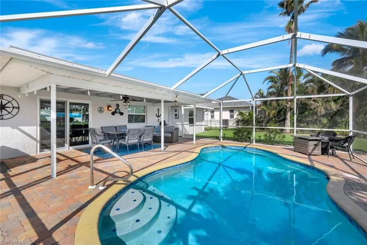 View of swimming pool featuring ceiling fan, a lanai, and a patio area