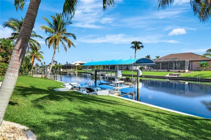 Dock area with a lawn and a water view