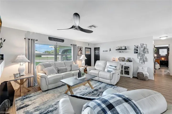 Living room featuring wood-style vinyl flooring and ceiling fan