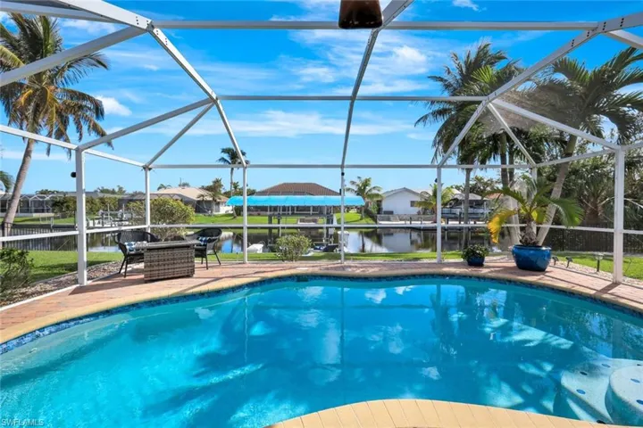 View of swimming pool with a lanai, a water view, and a patio area