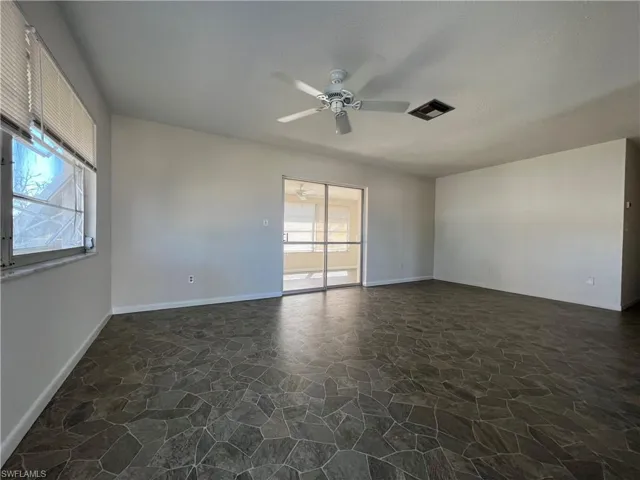Living room with ceiling fan, vinyl floors, and a healthy amount of sunlight