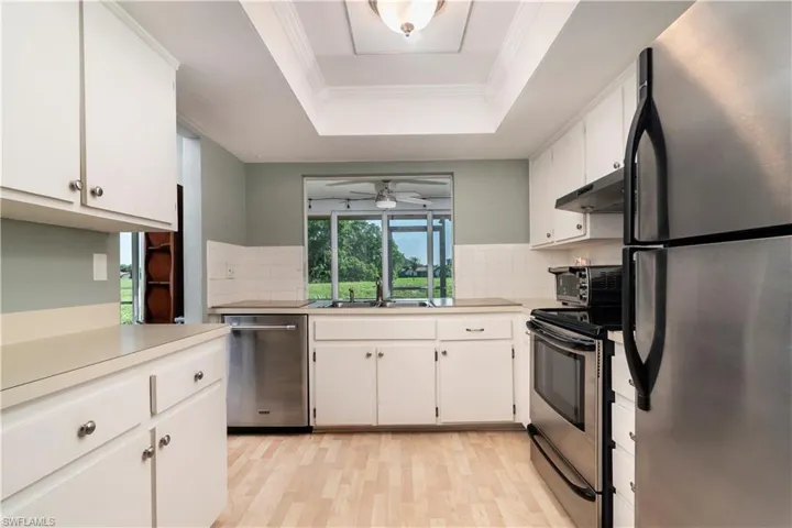 Kitchen featuring ceiling fan, stainless steel appliances, light wood-type flooring, and backsplash