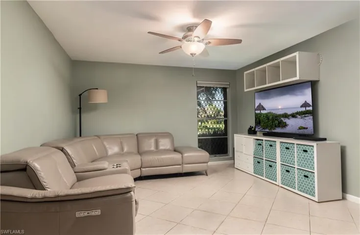 Tiled living room featuring ceiling fan