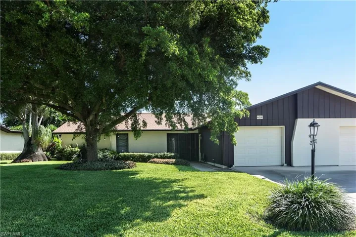Ranch-style house with a garage and a front lawn