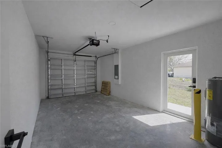 4529_Garage with a textured wall, water heater, and a garage door opener