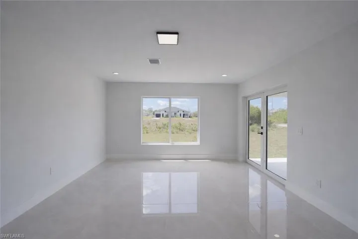 Unfurnished room with plenty of natural light and recessed lighting