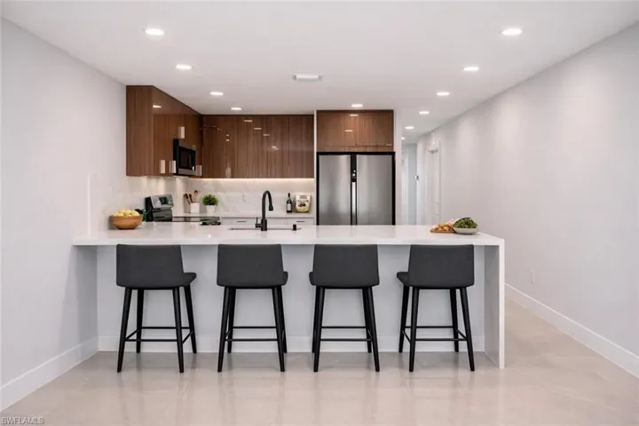 4529_Kitchen featuring a peninsula, light stone countertops, modern cabinets, stainless steel appliances, and recessed lighting