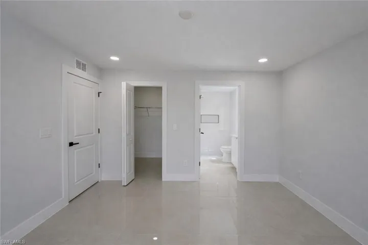 4529_Unfurnished bedroom featuring a spacious closet, recessed lighting, connected bathroom, and light tile patterned floors