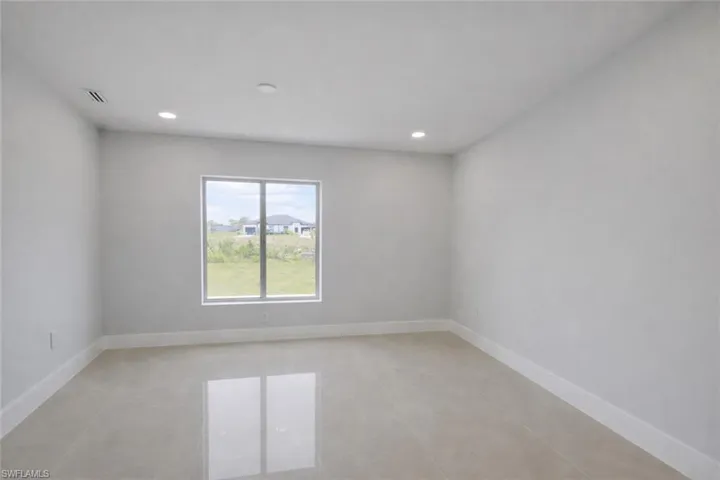 Empty room with baseboards and recessed lighting