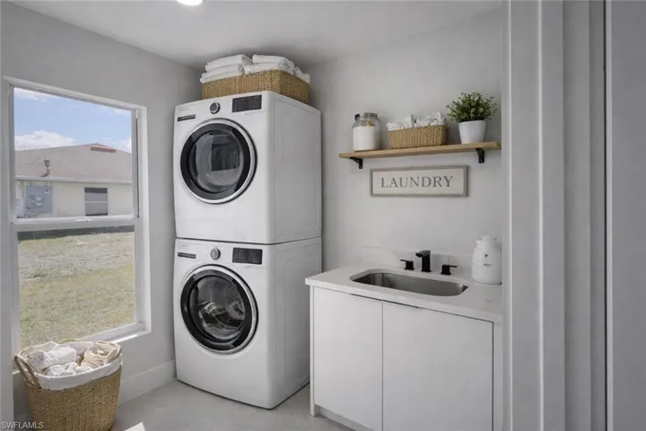4529_Laundry area featuring stacked washer / drying machine and cabinet space