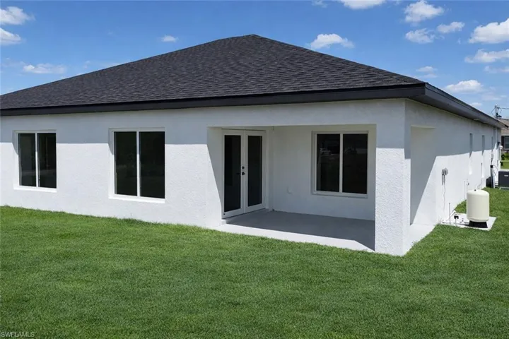 4529_Rear view of house featuring roof with shingles, a patio area, french doors, a lawn, and stucco siding