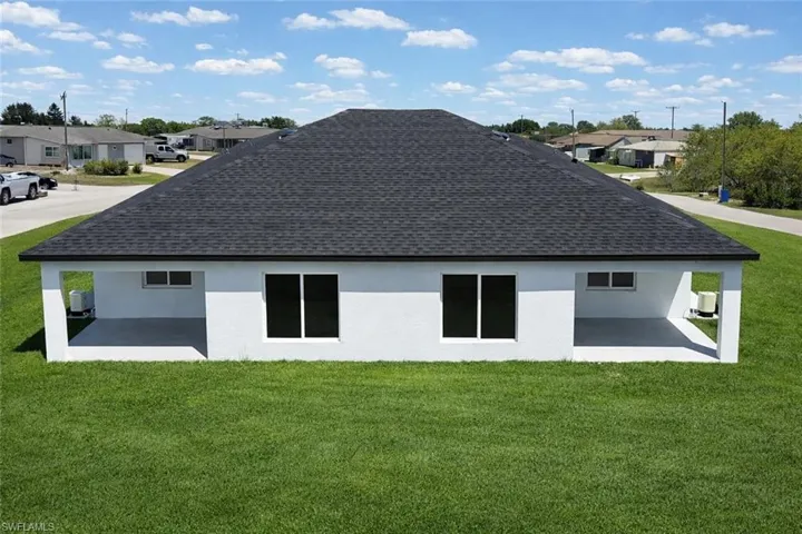 4531_Back of house with a yard, a patio, a shingled roof, and a residential view