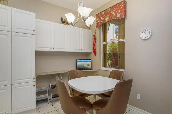 Tiled dining space featuring an inviting chandelier