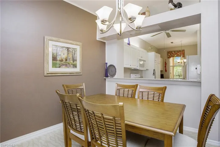 Dining room with ceiling fan with notable chandelier