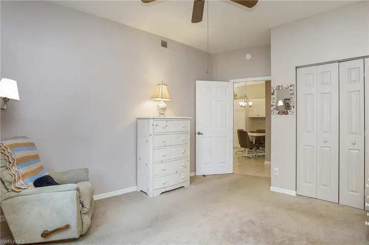 2nd Bedroom with ceiling fan with notable chandelier and light carpet