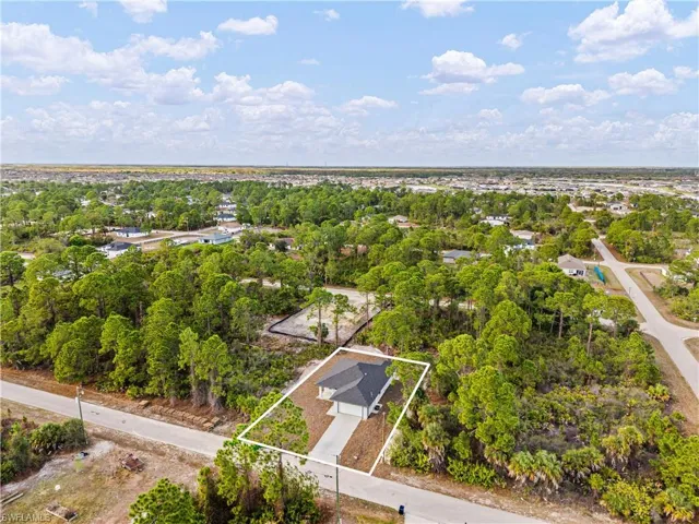 View of property location with property boundaries highlighted and a tree filled landscape