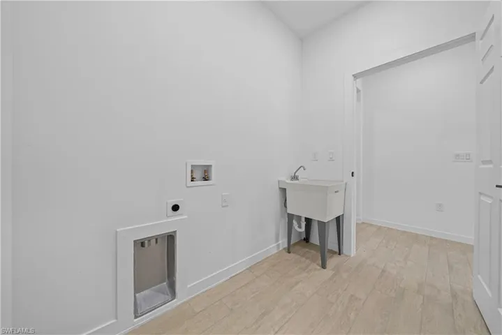 Laundry area featuring light wood finished floors, washer hookup, and electric dryer hookup