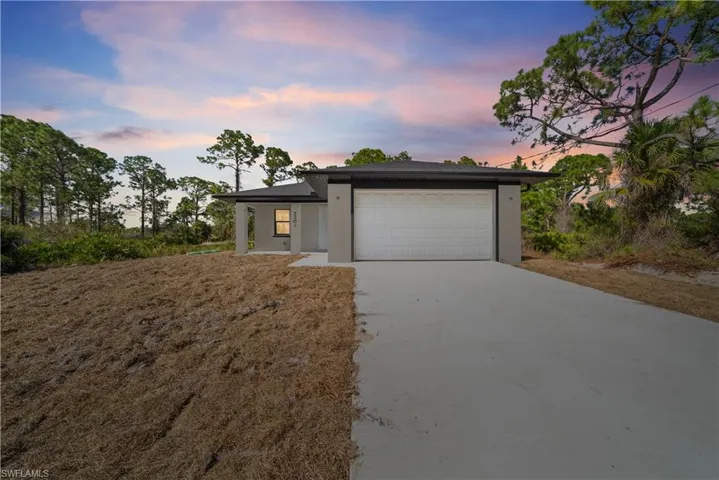 View of front facade with concrete driveway, a garage, and stucco siding
