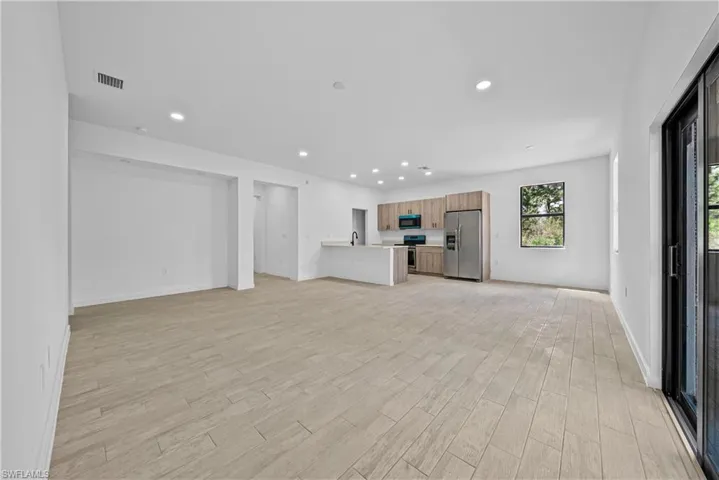 Unfurnished living room with wood tiled floors and recessed lighting
