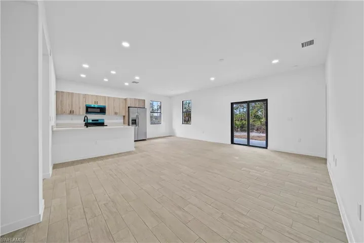 Unfurnished living room with wood finish floors and recessed lighting