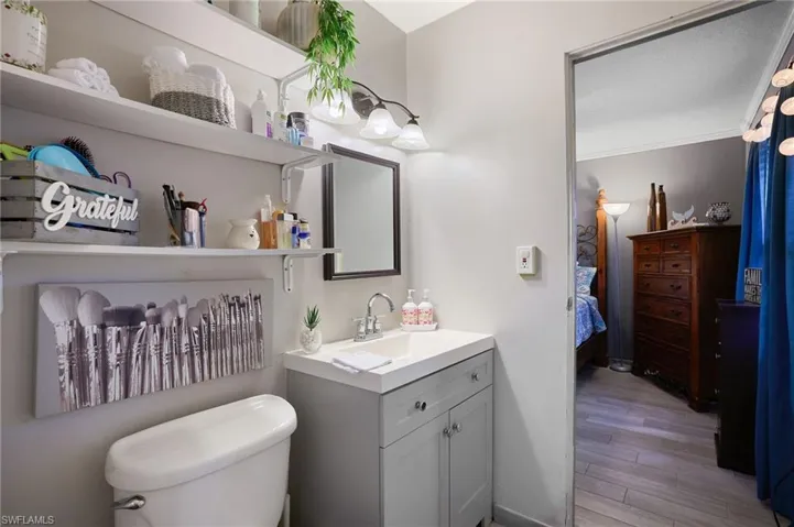 Bathroom featuring a single vanity with light grey cabinetry, a square undermount sink, and a framed mirror