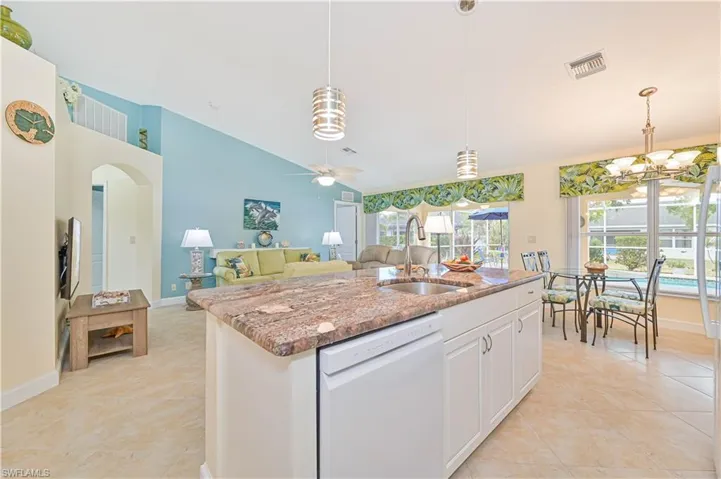 Kitchen featuring dishwasher, sink, pendant lighting, white cabinets