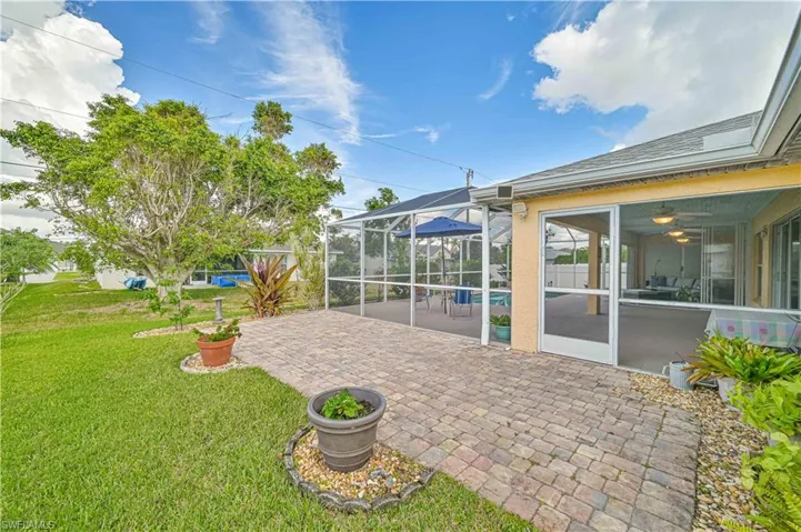 View of patio featuring a lanai and a swimming pool