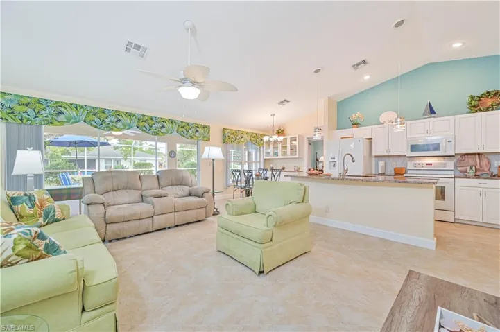Living room featuring ceiling fan, high vaulted ceiling