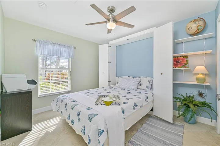 Tiled bedroom featuring ceiling fan