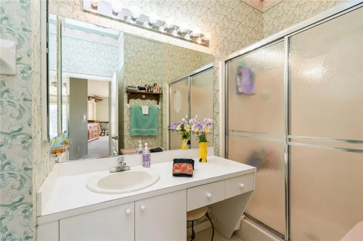 Bathroom with vanity and a shower with door