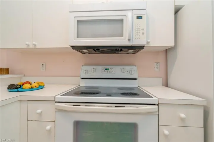 Kitchen featuring white cabinets and white appliances