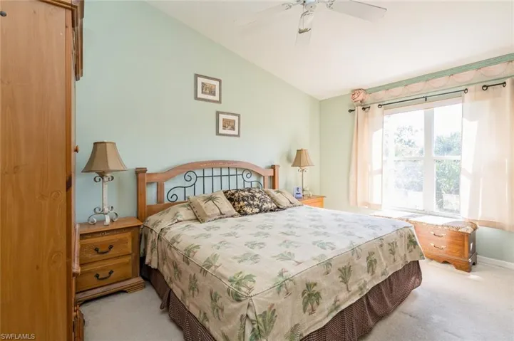 Bedroom featuring light colored carpet, ceiling fan, and lofted ceiling